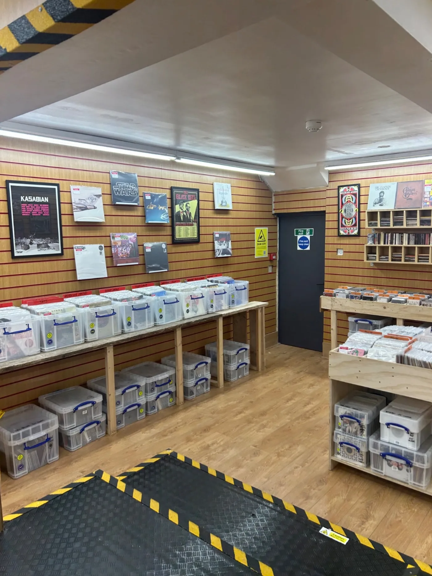 Record crates and display sleeves beside the upper shop doorway
