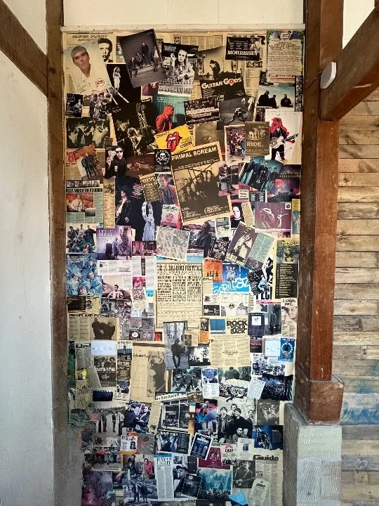Full-height music collage wall beside timber beams